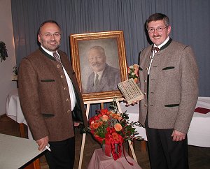 Leo Wöhr und Sepp Hatzl mit der Originalausgabe der Chronik vor einem Bildnis Brunhubers